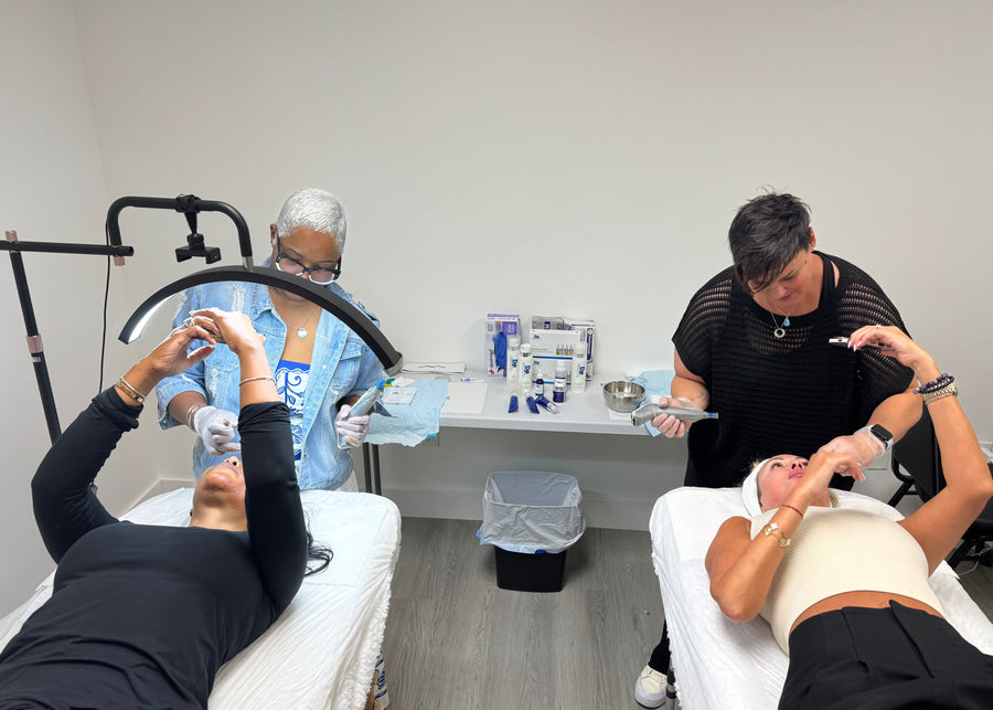 Two people receiving a cosmetic procedure in a clinical setting with medical equipment.